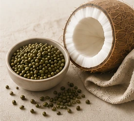 Halved coconut beside a bowl of green gram